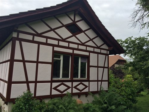 Fachwerkhaus Giebel, weiss mit dunkelrotem Balkenwerk gestrichen